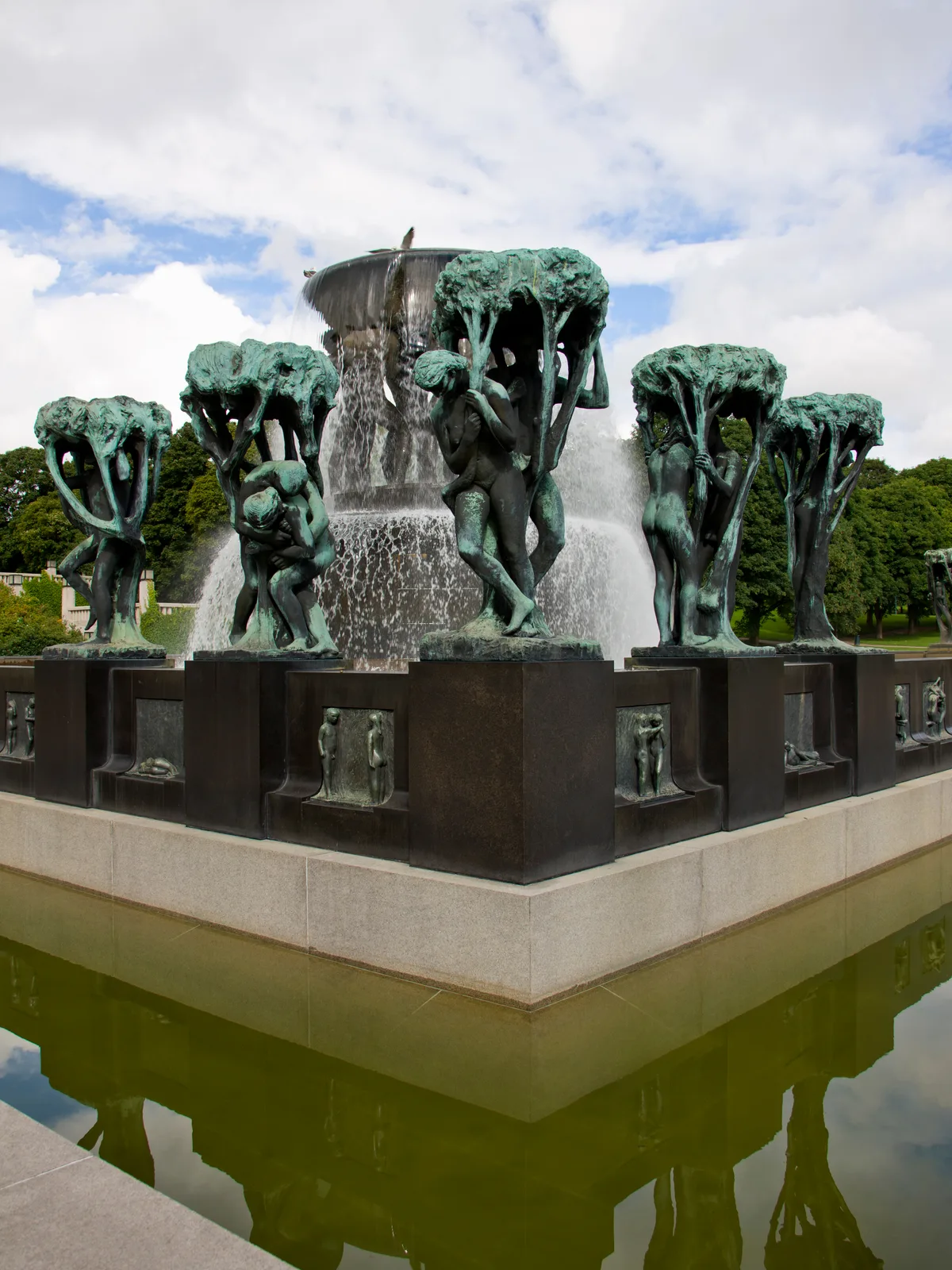 The Fountain with tree groups in Vigeland Park, Oslo: six bronze men carrying the great bowl together